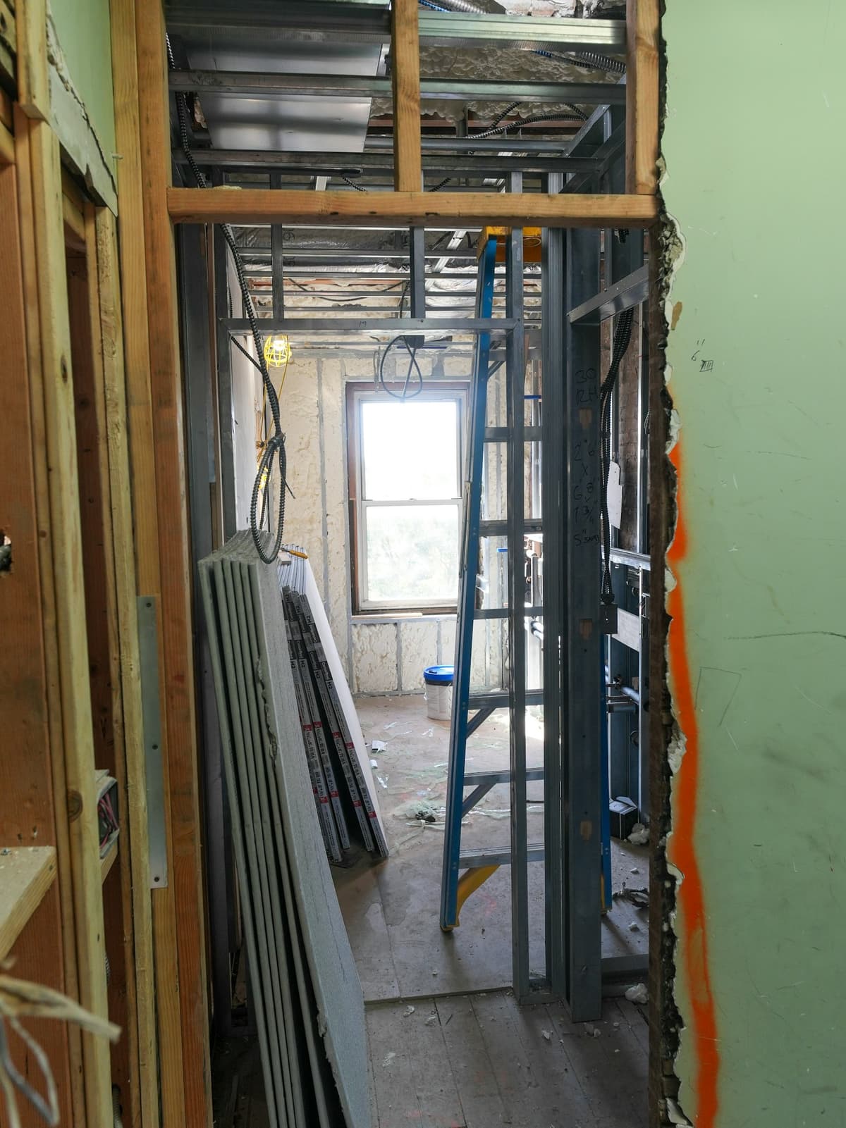 Interior home renovation in progress with framing and drywall materials